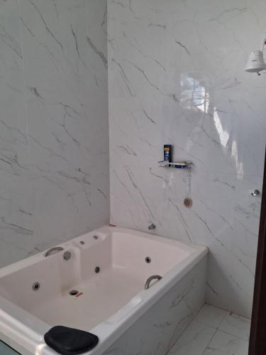 a white bath tub in a bathroom with marble walls at Casa em condomínio porto marina in Ananindeua