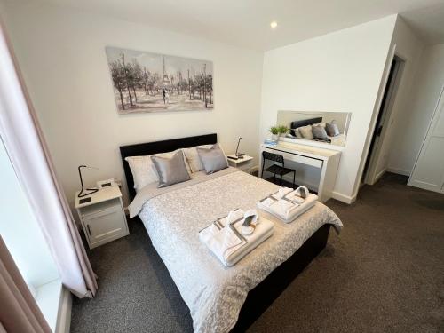 a bedroom with a bed with two towels on it at Royal Atlantic View Apartment in Portrush