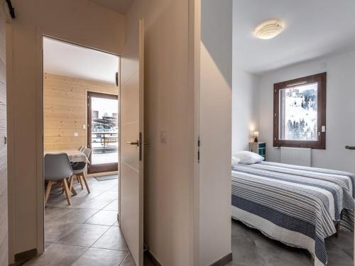 une chambre avec un lit et une table dans une pièce dans l'établissement Charmant appartement au cœur de La Plagne avec cuisine équipée et accès rapide aux pistes - FR-1-351-94, à La Plagne
