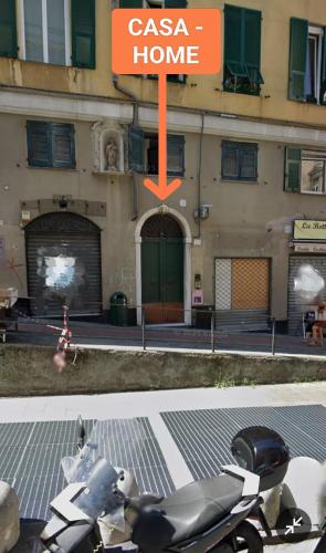 a scooter parked in front of a building with a home sign at Appartamento Esclusivo De Ferrari - Genova Centro Storico in Genova