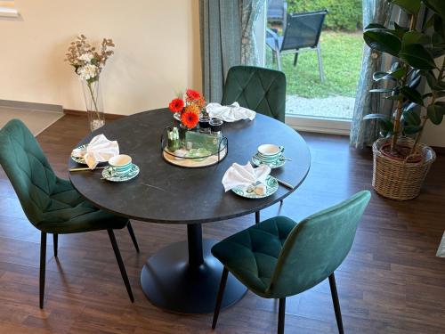 a black table with flowers and cups and chairs at WM GEDER Ferienwohnungen Werner in Lebring