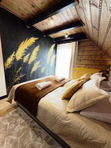 a bedroom with a large bed with a mural on the wall at Pod Źródełkiem in Cisna