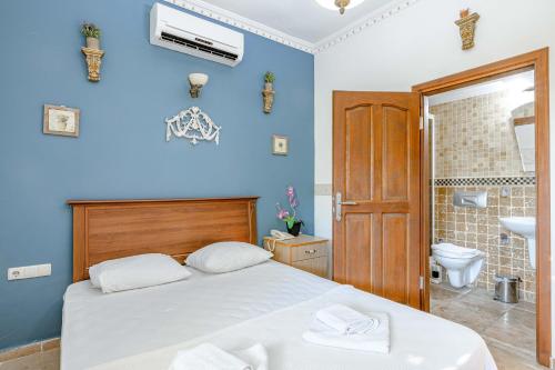 a blue bedroom with a bed and a bathroom at Casa Roma Boutique Hotel in Bodrum City