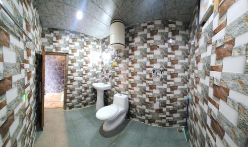 a bathroom with a toilet and a sink at Wood Heaven Farms in Shimla
