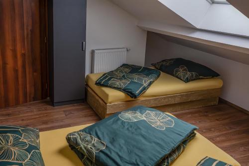 two twin beds in a small room with a staircase at Penzion Ronox in Česká Skalice
