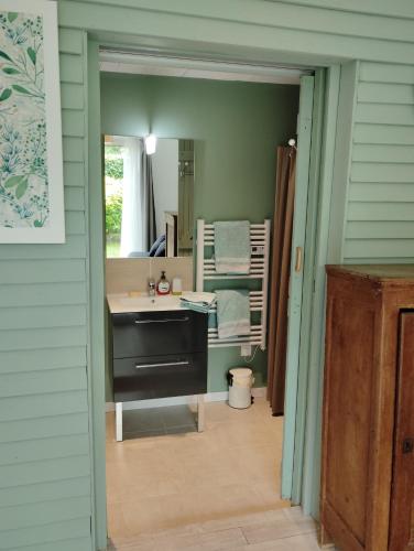 une salle de bain avec un lavabo et un miroir dans l'établissement Au p'tit jardin, à Saint-Sylvestre-de-Cormeilles