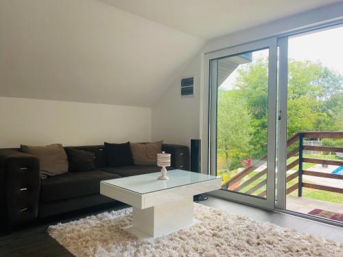 a living room with a couch and a table at Apartman Maslina in Kosjerić