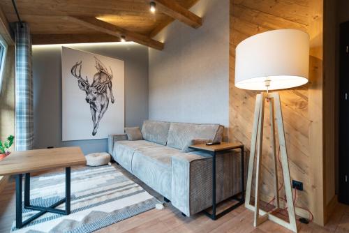 a living room with a couch and a lamp at Ośrodek Wypoczynkowy Bernadetta in Murzasichle