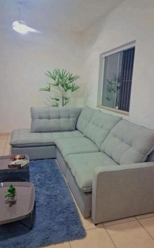 ein Wohnzimmer mit einem blauen Sofa und einem blauen Teppich in der Unterkunft Casa Vila Santa Cecília - No Centro da Cidade in Volta Redonda