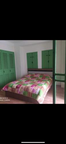 a bedroom with a bed with green headboards and a bed sidx sidx at Green house in Sidi Yahia az Zaʼer