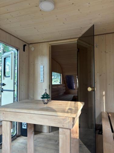 a wooden table in the front of a tiny house at Glamp Juodis in Ubiškės