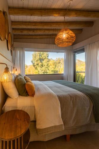 a bedroom with a large bed and a large window at Cabañas Rio Soñado in Valle Grande