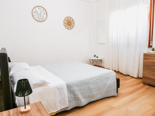 una camera bianca con un letto bianco e un pavimento in legno di Sea House Fortore a Montesilvano