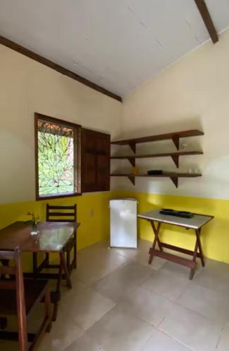 a kitchen with a table and a refrigerator in a room at Anjali in Ilha de Boipeba