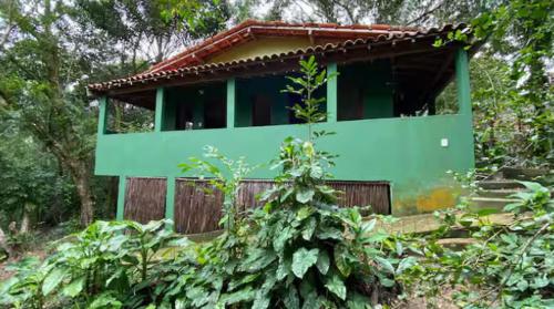 a green building in the middle of a forest at Anjali in Ilha de Boipeba