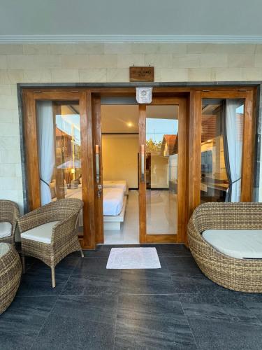 a room with a bed and two wicker chairs at The Kanha Palace in Nusa Penida