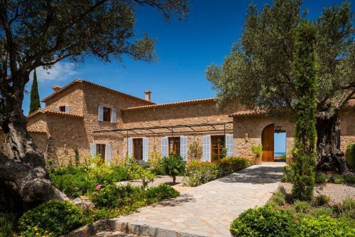 an exterior view of a stone house with trees at Secluded Oasis in Banyalbufar City, 1020 in Banyalbufar