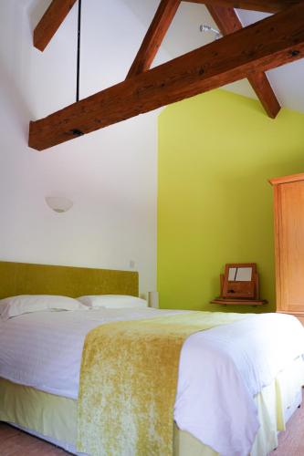 a bedroom with a bed and a green wall at The Courtyard at Lodge Farm in Norwich