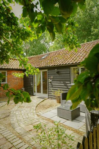 a small house with a patio in front of it at The Courtyard at Lodge Farm in Norwich