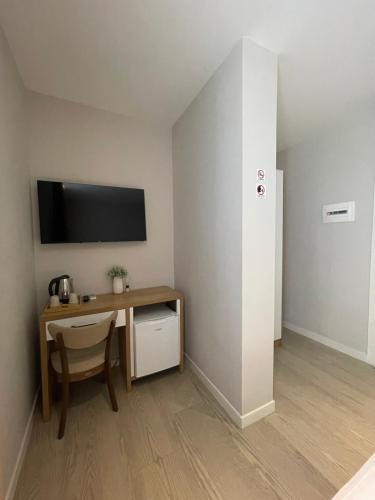 a room with a desk and a tv on a wall at Solea Hotel in Vlorë