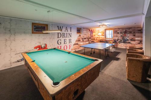 a pool table in a room with two tables at Waidringer Hof 4 Sterne Superior in Waidring