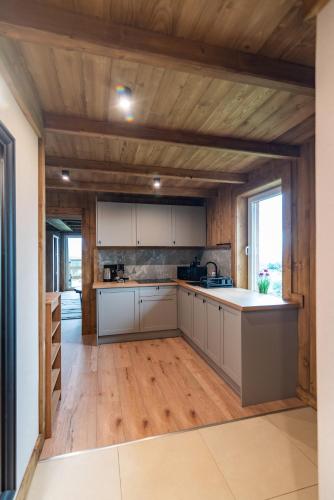 a kitchen with white cabinets and a wooden ceiling at Ośrodek Wypoczynkowy Bernadetta in Murzasichle