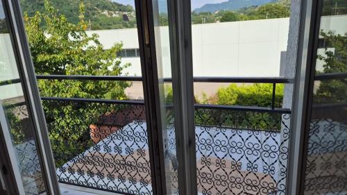 an open window with a view of a garden at ruhiges Haus am See in Agno in Agno