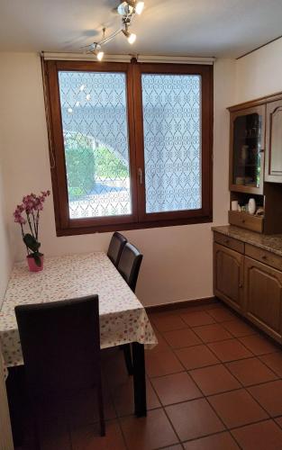 a kitchen with a table with chairs and a window at ruhiges Haus am See in Agno in Agno