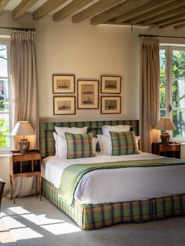 a bedroom with a large bed with two tables and two lamps at Le Clos de Grâce in Honfleur