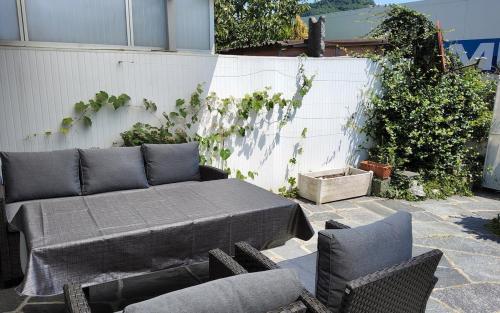 a patio with a table and chairs and a fence at ruhiges Haus am See in Agno in Agno