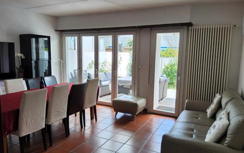 a living room with a couch and a table and chairs at ruhiges Haus am See in Agno in Agno