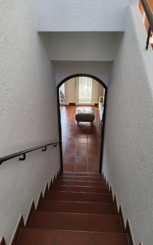 a hallway with a stairway with a couch in a room at ruhiges Haus am See in Agno in Agno