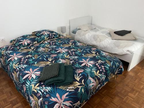 a bedroom with a bed with a flower patterned blanket at La maison du bonheur in Kérien