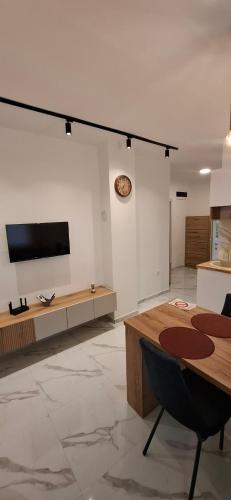 a living room with a table and a tv on a wall at Apartman Marija in Kladovo