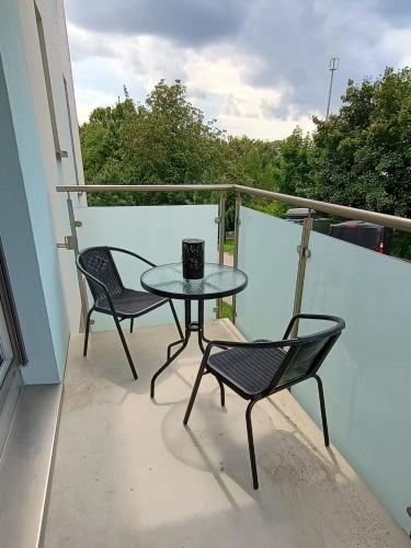 a table and two chairs sitting on a balcony at Mieszkanie Oborniki Śląskie in Oborniki Śląskie