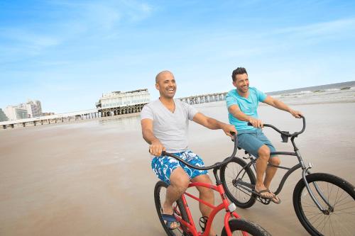 two men riding bikes on the beach at Holiday Inn Hotel & Suites Daytona Beach On The Ocean by IHG in Daytona Beach