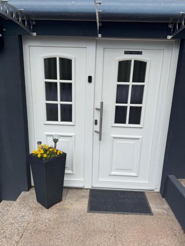 a white door with a window and a basket of flowers at Ferienwohnung Südwestpfälzer Ruheoase in Busenberg