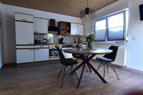a kitchen with a table and chairs in a room at Ferienwohnung Südwestpfälzer Ruheoase in Busenberg