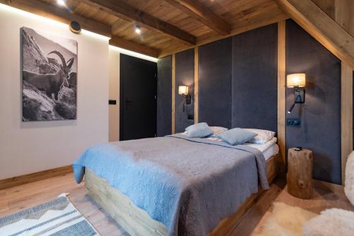 a bedroom with a bed and a picture of a deer at Ośrodek Wypoczynkowy Bernadetta in Murzasichle