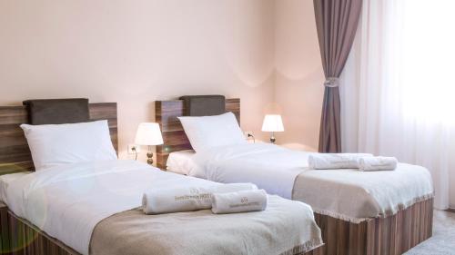Łóżko lub łóżka w pokoju w obiekcie Semitronix Hotel Prishtina