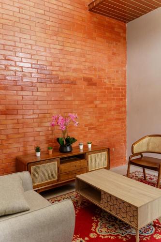 a living room with a brick wall and a coffee table at Griya Saka Magelang in Magelang