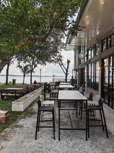 a row of tables and chairs in front of a building at PD Dwharf The Bay Oceanview Suite in Port Dickson