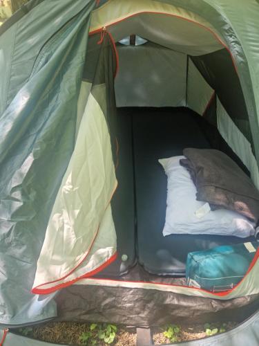 an inside of a green tent with a bed in it at Stala la la Camping in Požega
