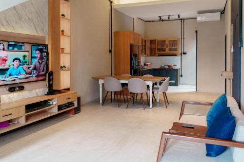 a living room with a dining room table and a tv at Griya Saka Magelang in Magelang
