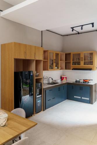 a kitchen with blue cabinets and a black refrigerator at Griya Saka Magelang in Magelang