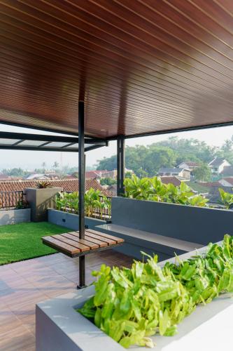 a patio with a wooden bench on a roof at Griya Saka Magelang in Magelang
