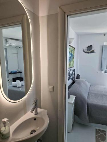 a bathroom with a sink and a bed and a mirror at Villa Dakoronia in Fira