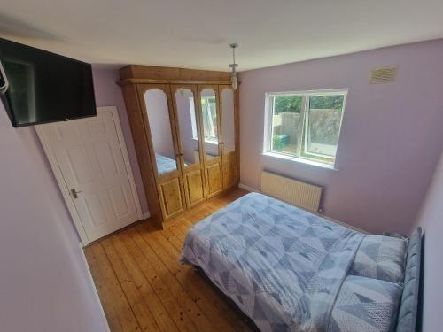 a bedroom with a bed and a cabinet and a window at 19 college Green in Wexford