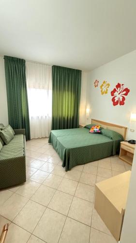 a hotel room with two beds and a couch at Ibisco Hotel in Rodi Garganico