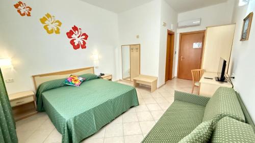 a bedroom with a green bed and a couch at Ibisco Hotel in Rodi Garganico